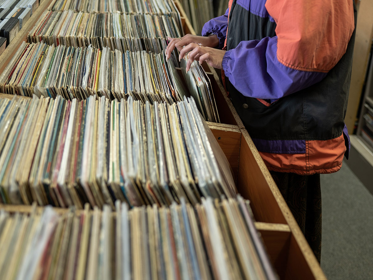 Someone digging through crates of vinyl records.