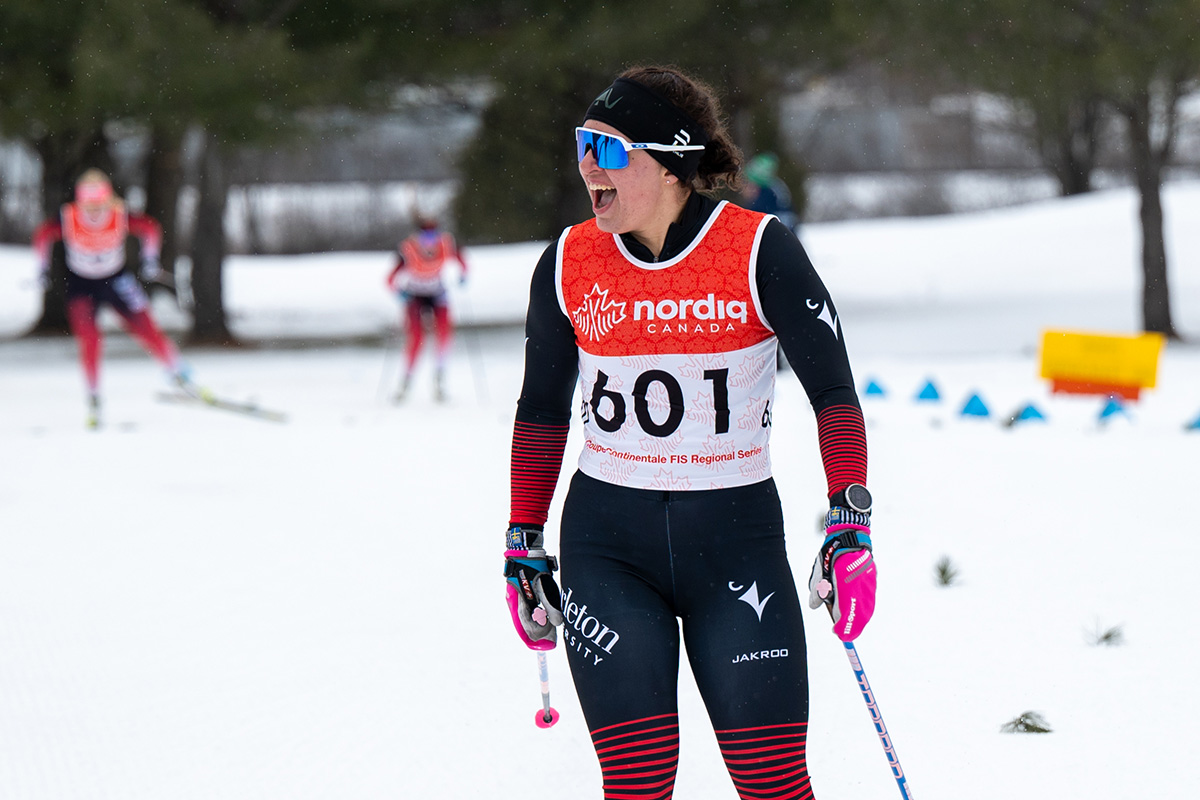 A skier laughing while on the slopes, used as an example of how Carleton Ravens women are excelling in their respective athletic programs.