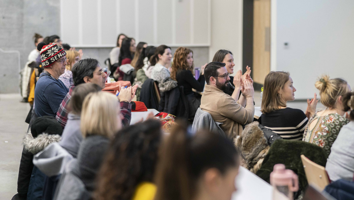 An audience clapping in a lecture hall.