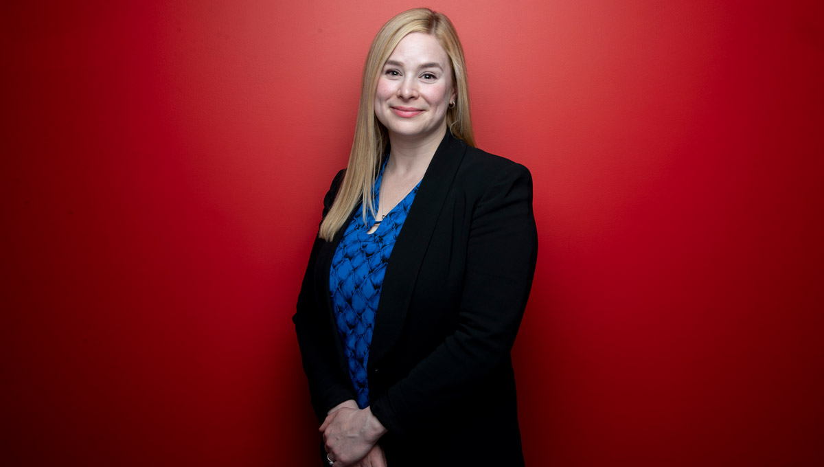 Kristin Connor poses against a red backdrop.