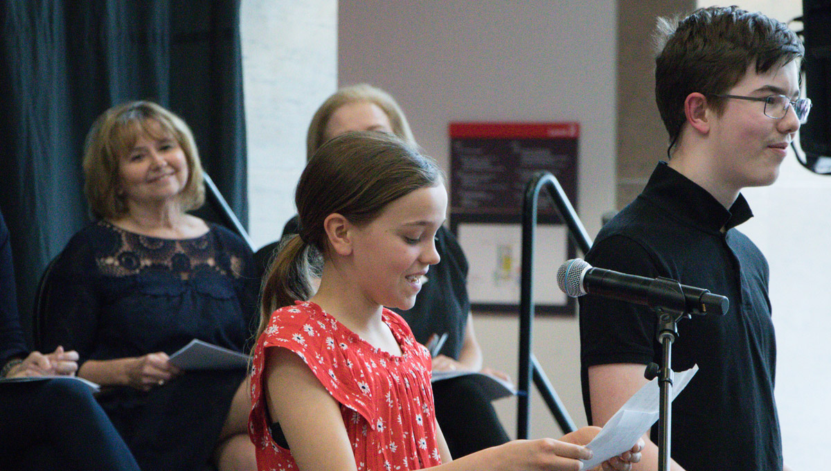 A girl speaks into a microphone during the International Year of the Child celebration.