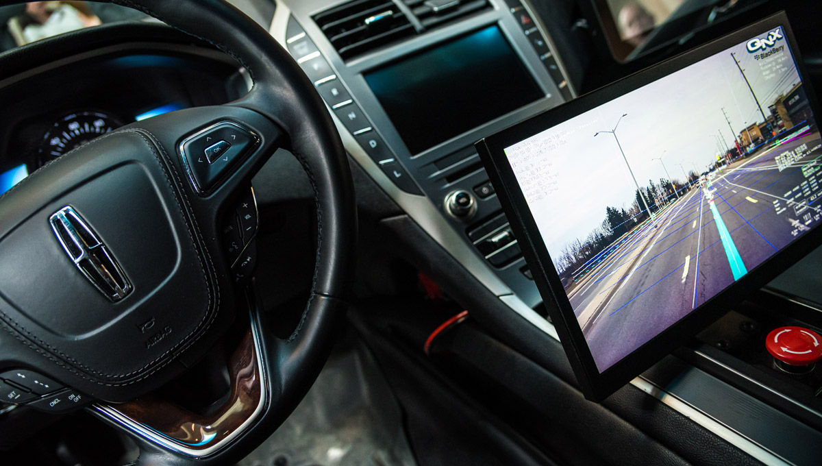 The interior of a connected and autonomous vehicle with a prominent screen displaying autonomous information.