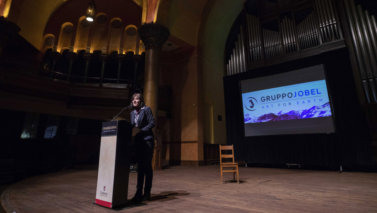 A woman speaks at a podium on stage at the Dominion-Chalmers Centre.