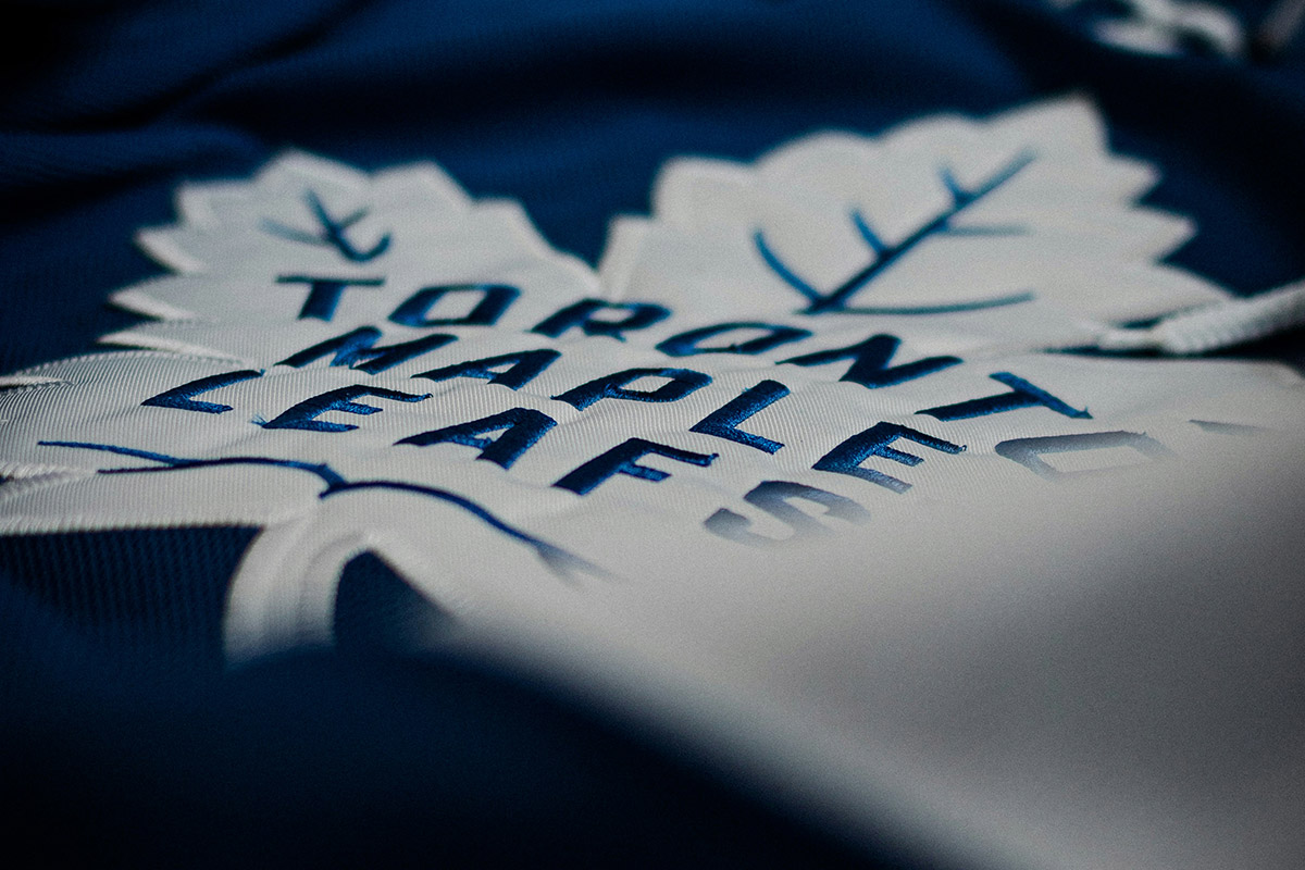 The logo of the Toronto Maple Leafs team is seen at close range on a jersey.