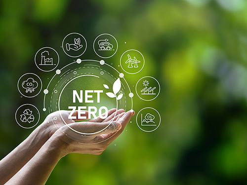 A design concept representing carbon neutrality and net-zero. A hand holds a net-zero icon which is surrounded by other smaller icons representing emissions targets.