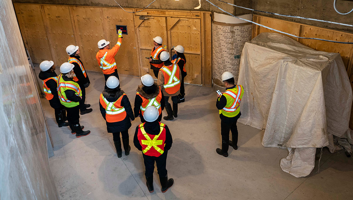Members of the Carleton community survey the construction progress of the Nicol Building