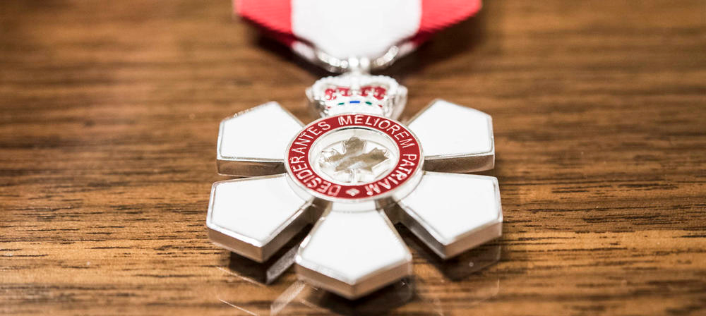 Insignia for the Order of Canada is displayed on a wooden surface