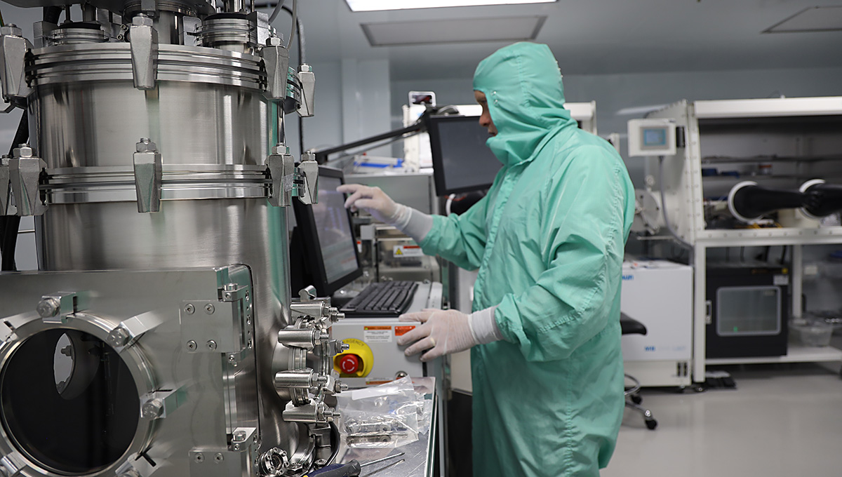A man wears protective lab gear while working