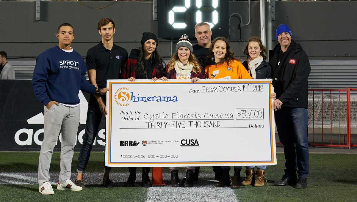 President Benoit-Antoine Bacon joined students representatives during a Redblacks Game in October 2018 to present Shinerama proceeds to Cystic Fibrosis Canada.