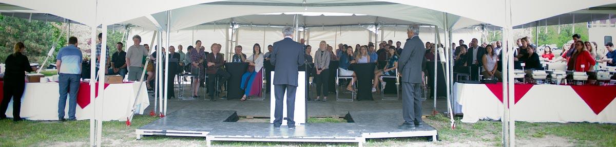 Solar Energy Solutions: speeches are given at a podium outside of the Urbandale Centre.