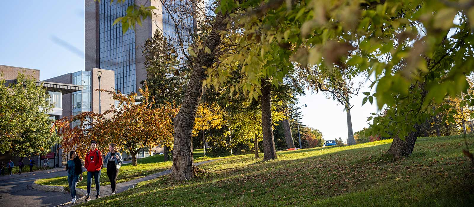 Studentts walking through university campus with buildings in the background