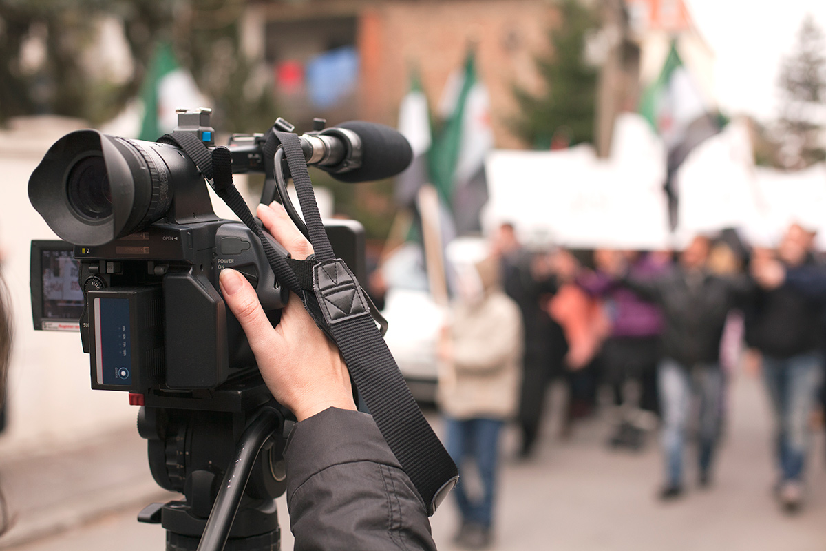 A behind the lens view of a photographer taking photos of a protest.