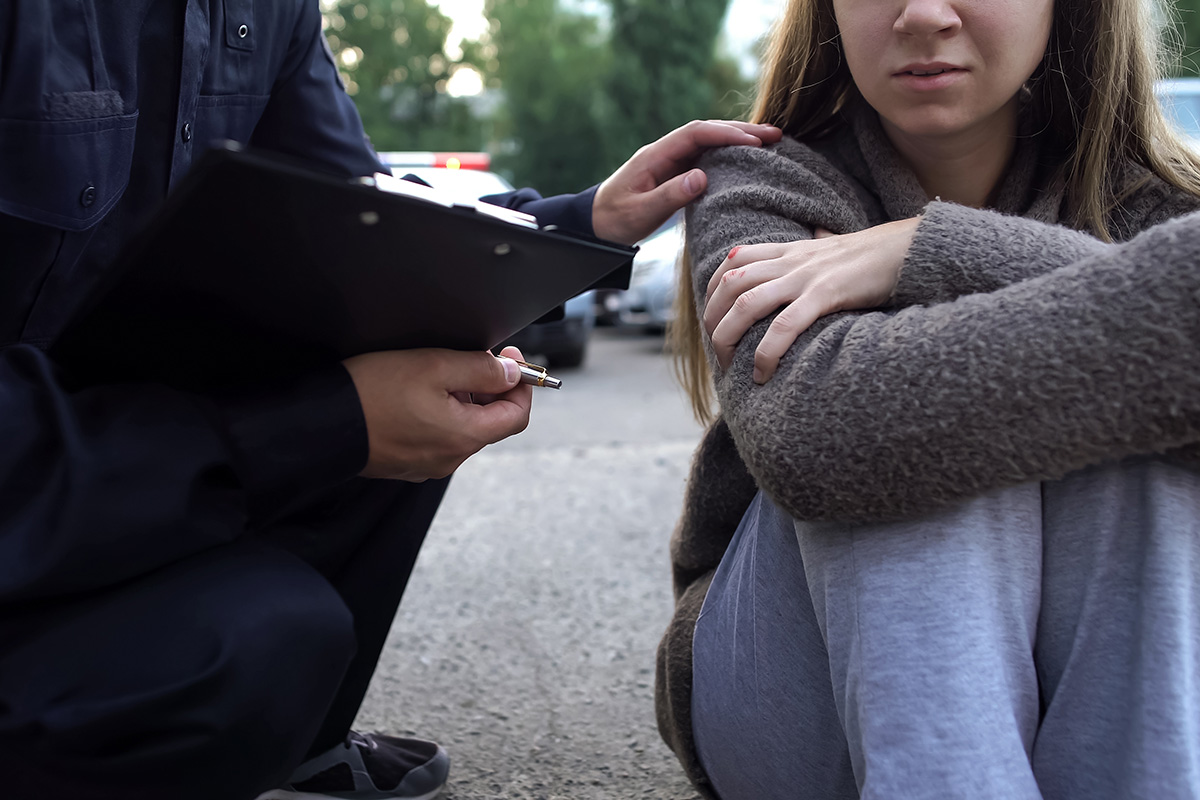 A person comforts a young girl that is visibly upset.