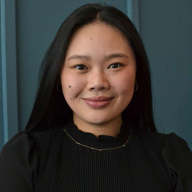 A professional headshot of a young woman wearing a black shirt.