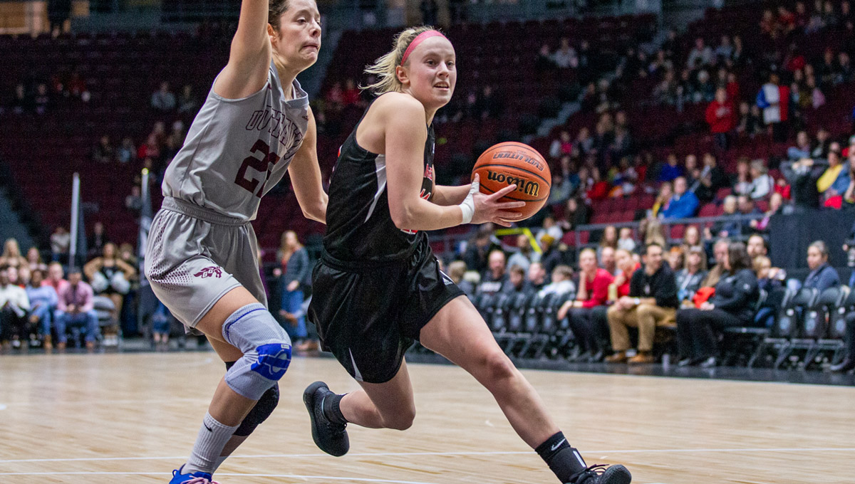 A Ravens women's basketball player goes to the basket against a uOttawa Gee Gees player.